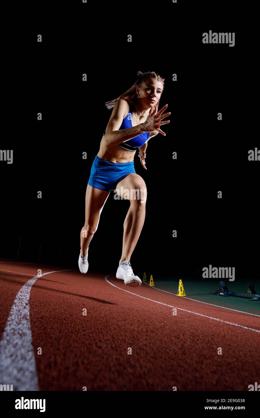 Female track runner bursting off starting block Stock Photo Alamy