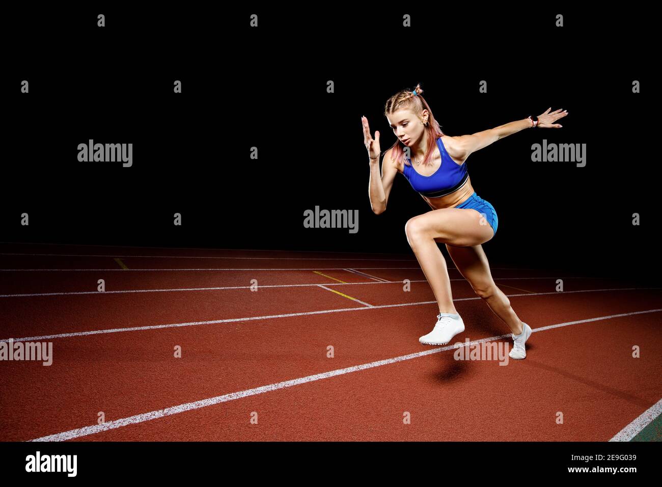 Female track runner bursting off starting block Stock Photo Alamy