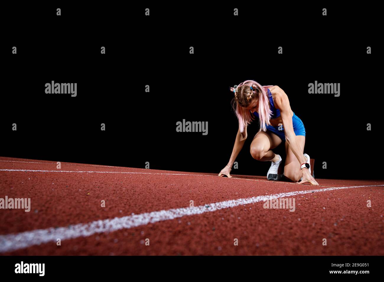 Female track runner on the starting block Stock Photo Alamy