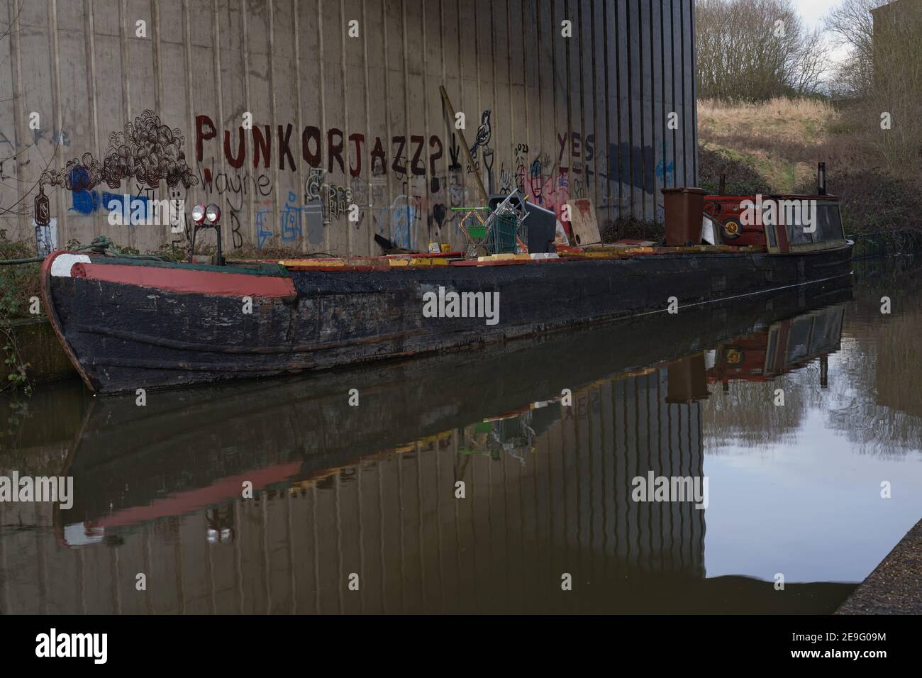 Hippy looking canal boat with a nice backdrop of grafitti including the words Punk or Jazz Stock Photo