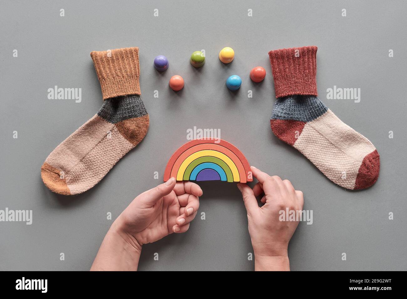 Odd Socks Day.Mismatched socks, wooden rainbow and toy figures. Social