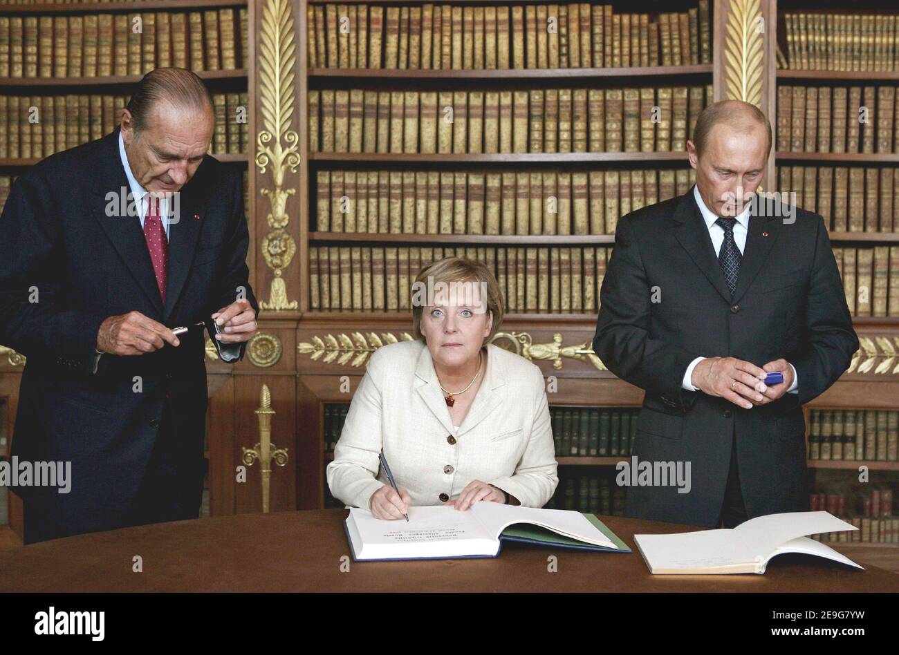 Germany's Chancellor Angela Merkel (c)signs the Livre d'Or (Guest Book) asRussia's President Vladimir Putin (R) and France's President Jacques Chirac watch to end a three-way summit in Compiegne, north of Paris, France on september 23, 2006. Photo pool by Romuald Meigneux/ABACAPRESS.COM Stock Photo