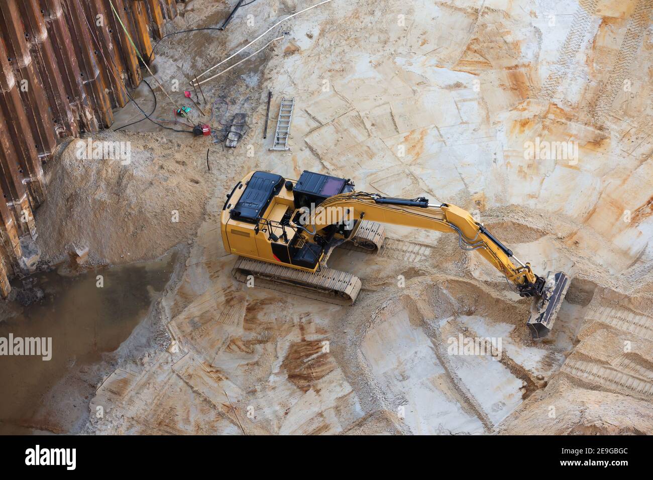 digger in construction pit with sheet piling Stock Photo