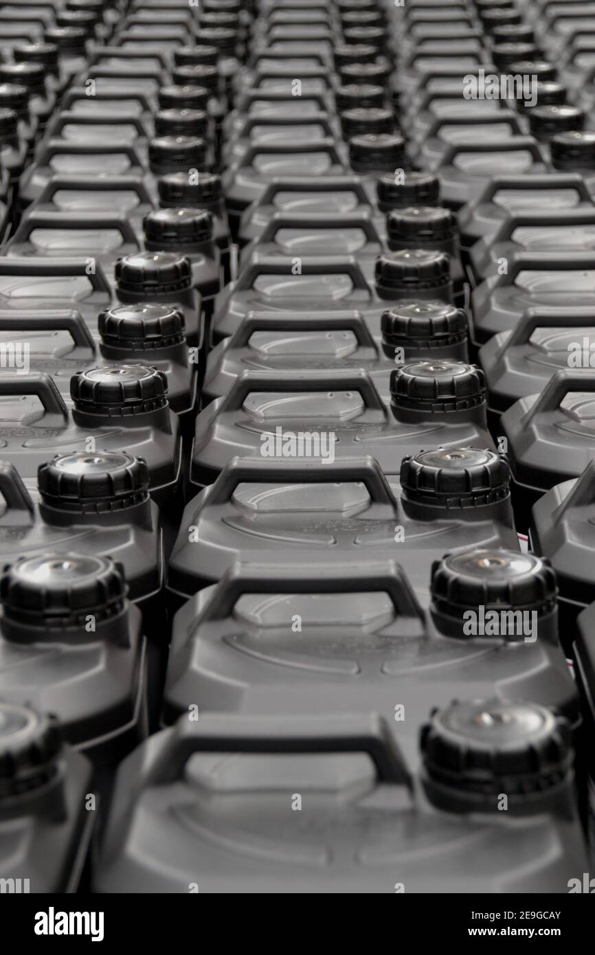 Full frame closeup angle of many black plastic bottles an containers with handles and caps in symmetrical angle Stock Photo
