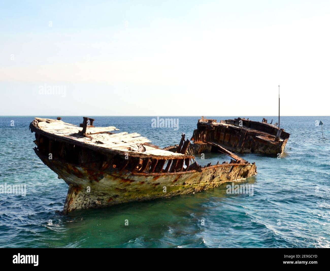 Old rusty ship wreck on the Great Barrier Reef in shallow water used as a diving and snorkeling artificial reef near Heron Island on a sunny clear day Stock Photo