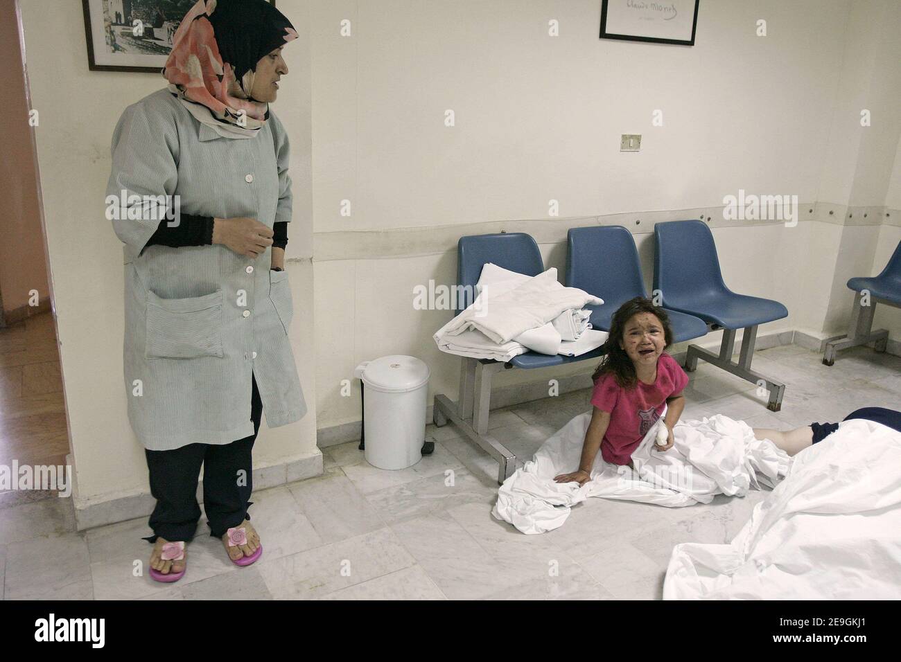 A young wounded girl sits on the floor of the waiting room at Najem hospital in Tyre, after a convoy of seventy civilians escorted by the Red Cross was hit by Israeli airstrikes as they were fleeing the southern Lebanese village of El Tiri. Photo by Michael Dohrn/ABACAPRESS.COM Stock Photo