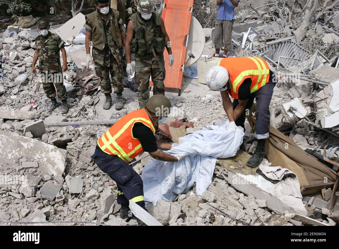 United Nations and Lebanese army soldiers cover the body of a small girl found in the rubble of a destroyed building that was bombed by Israeli warplanes last week in the outskirts of the southern coastal city of Tyre, Lebanon, on July 26, 2006. Photo by Michael Dorhn/ABACAPRESS.COM Stock Photo