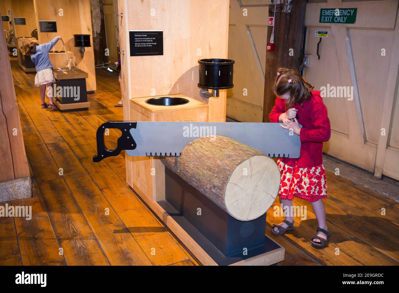 Young girl / child / children / kid / kids / tourist interacting and playing with interactive soaring timber and wood for masts for ships, display and displays part of the 'Command of the Ocean Gallery' at the Historic Dockyards in Chatham, Kent UK (121) Stock Photo