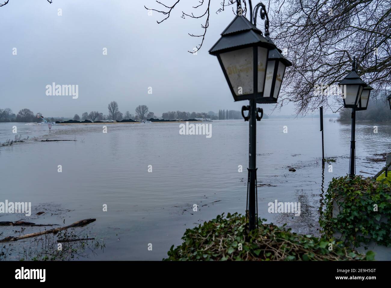 High water on the Rhine near Düsseldorf-Kaiserswerth, foggy weather, riverside paths and Rhine meadows are partly flooded, flooded restaurant garden, Stock Photo