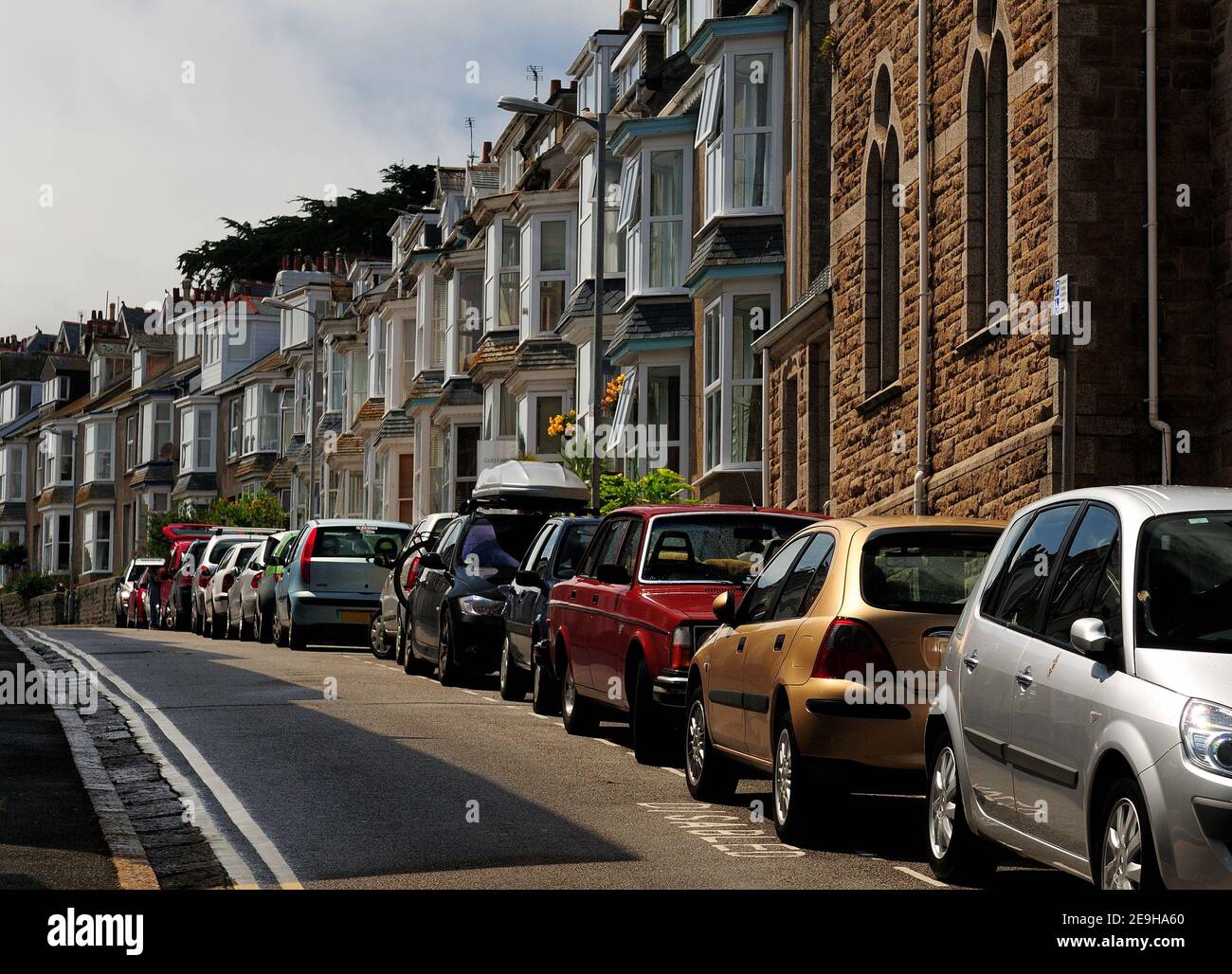Cars Parking In Front Of Charming Row Houses At Bedford Road St Ives Cornwall England On A Sunny Summer Day With A Few Clouds In The Sky Stock Photo
