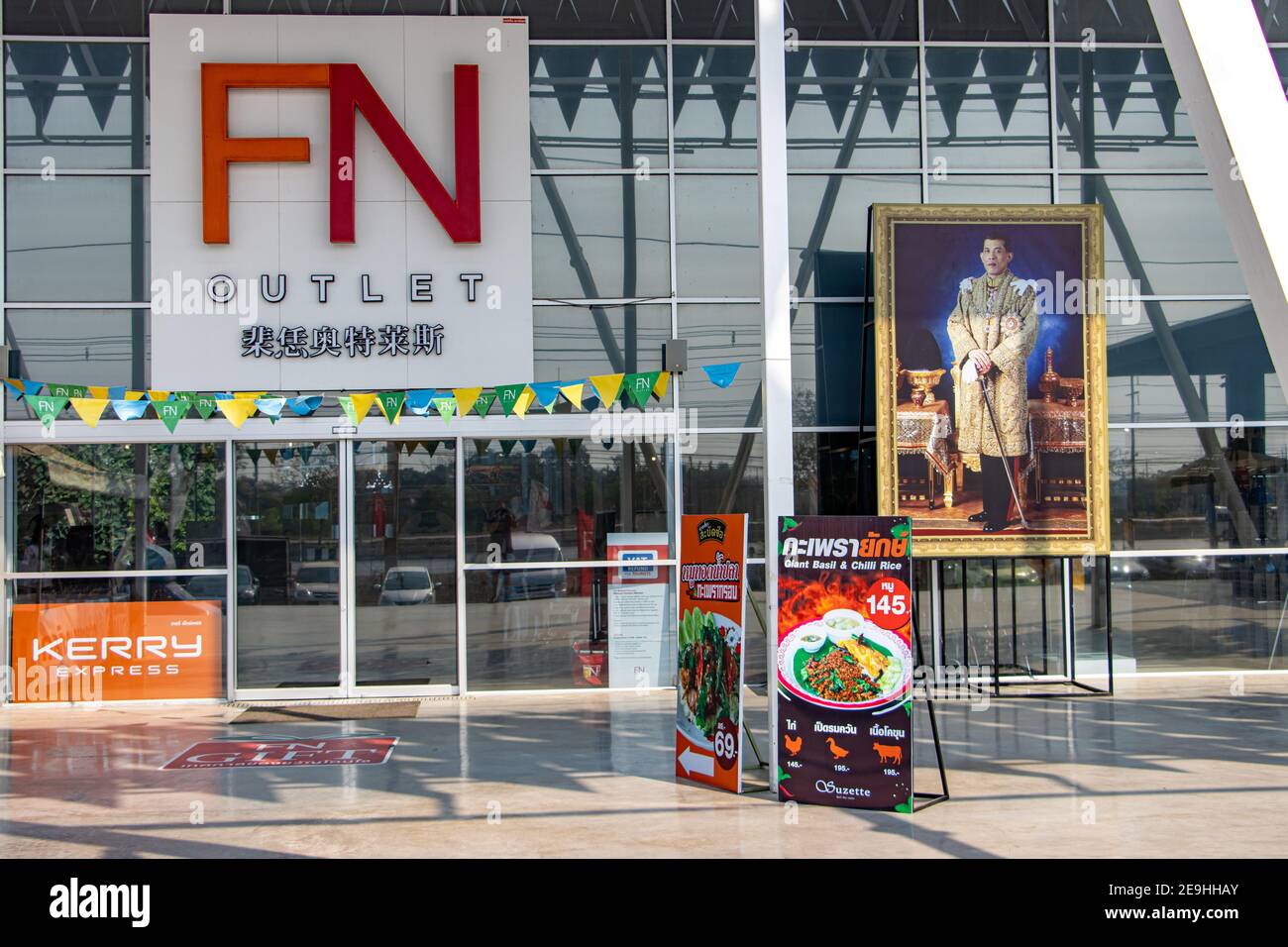 The main entrance to the outlet mall with the image of the Thai king. Stock Photo