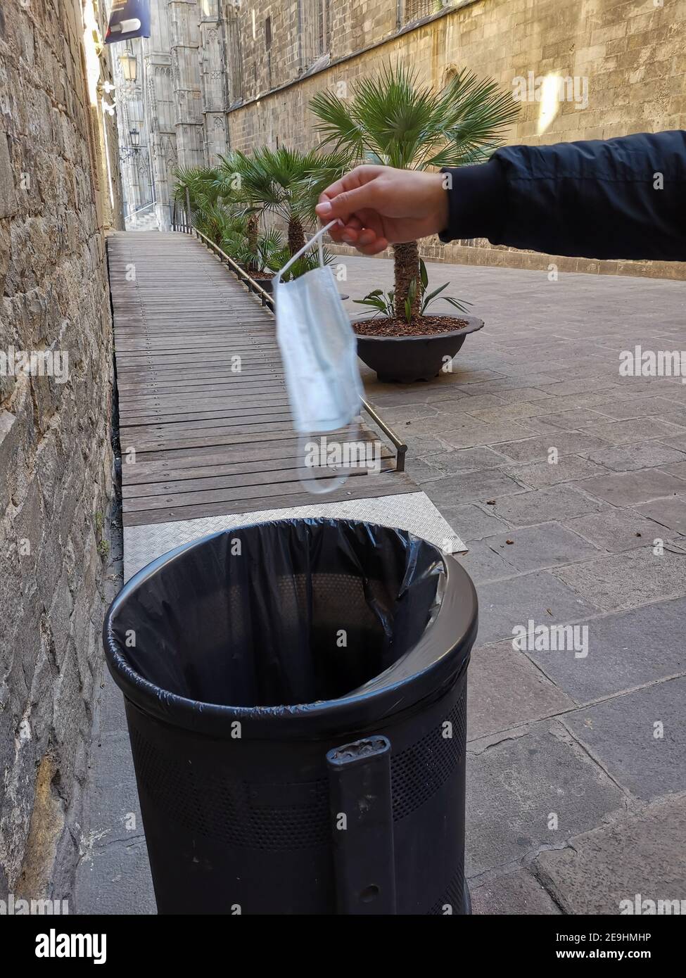 Vertical shot of a person throwing a face mask in the trash Stock Photo