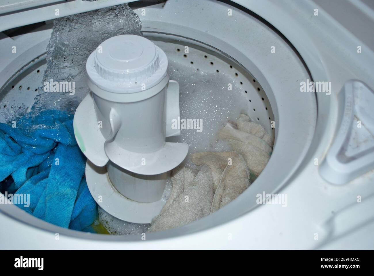 load of dirty towels in a washing machine filling with water Stock