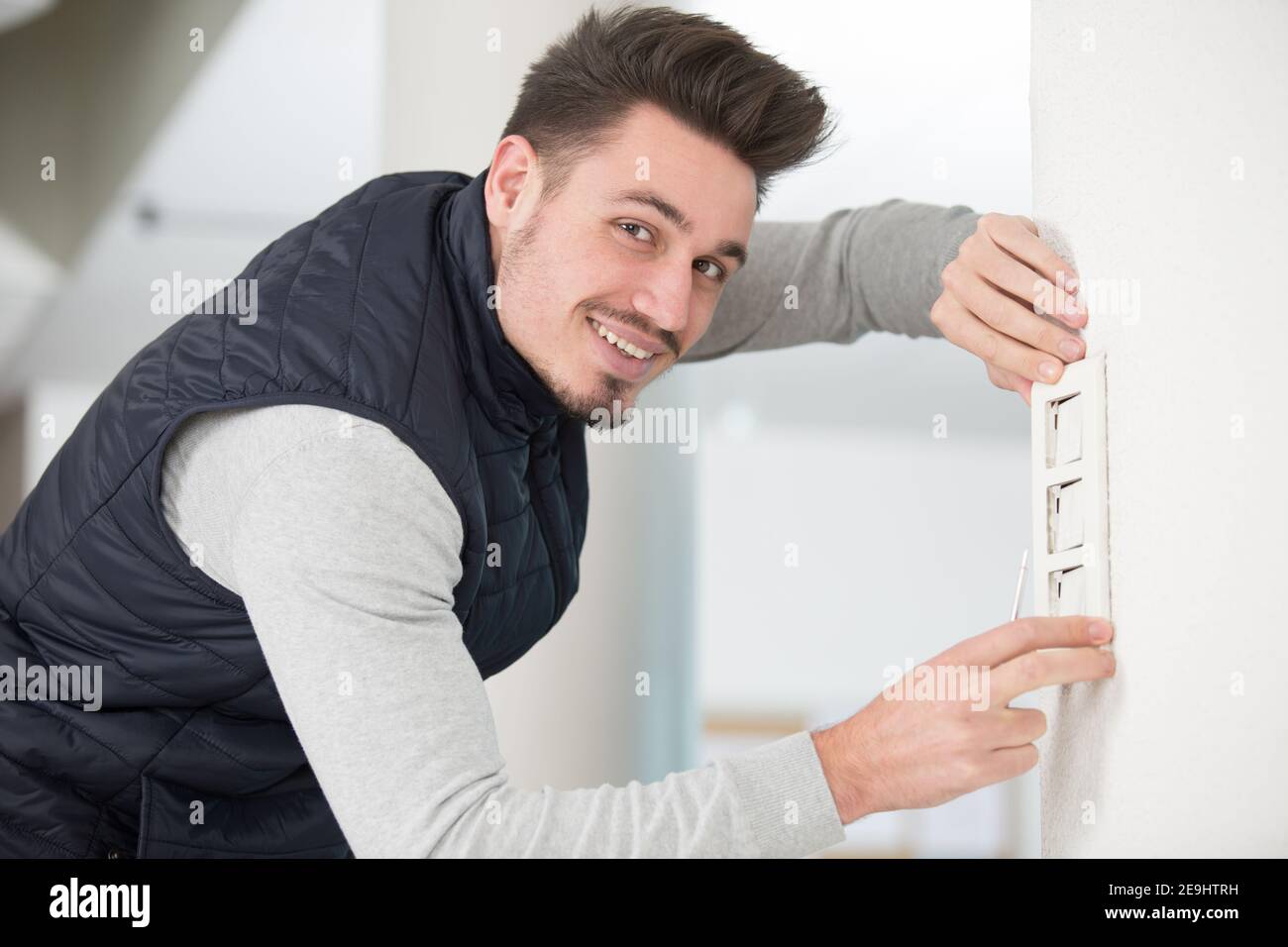 electrician man installing switch Stock Photo