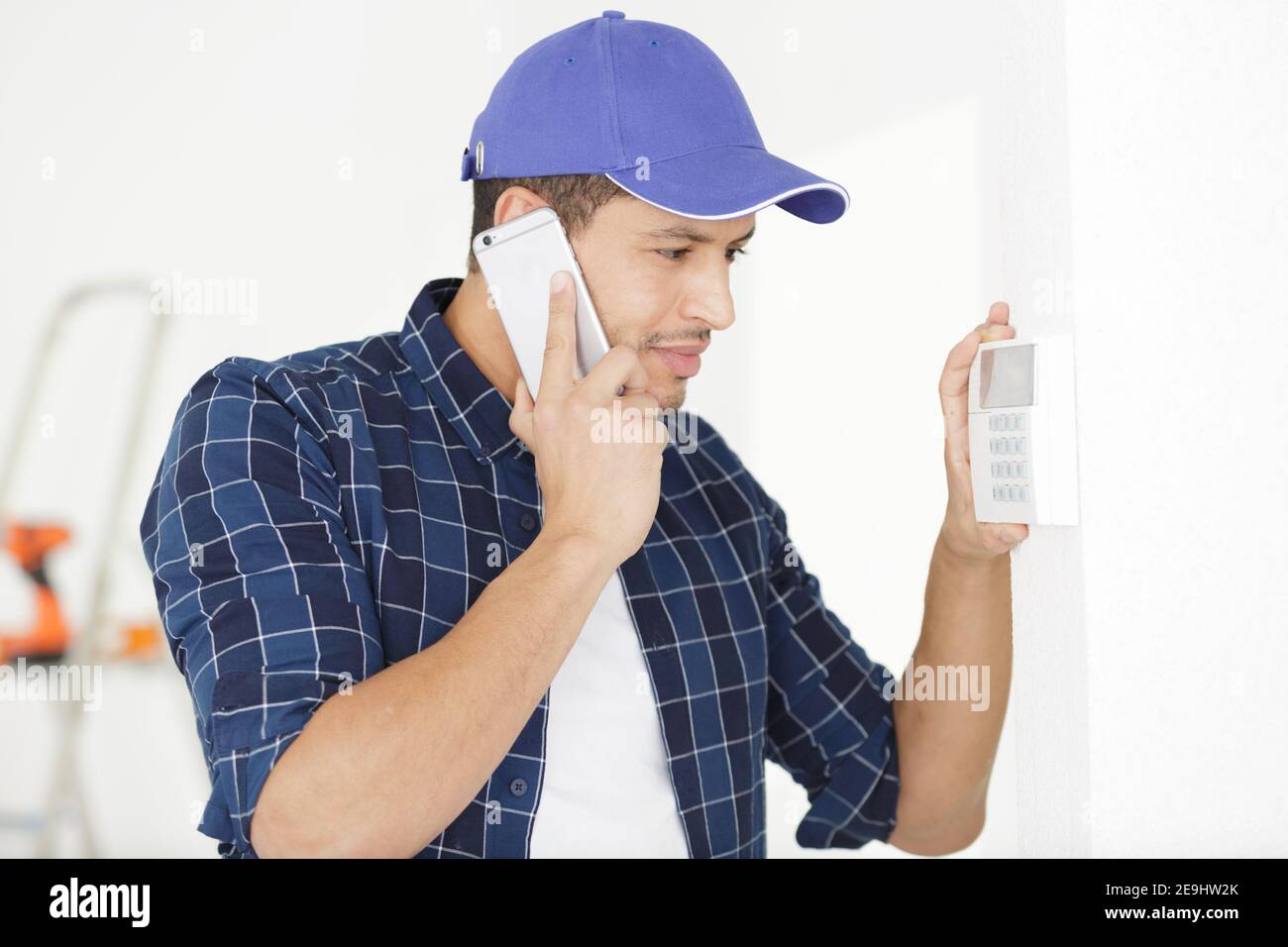 young electrician installing alarm system Stock Photo