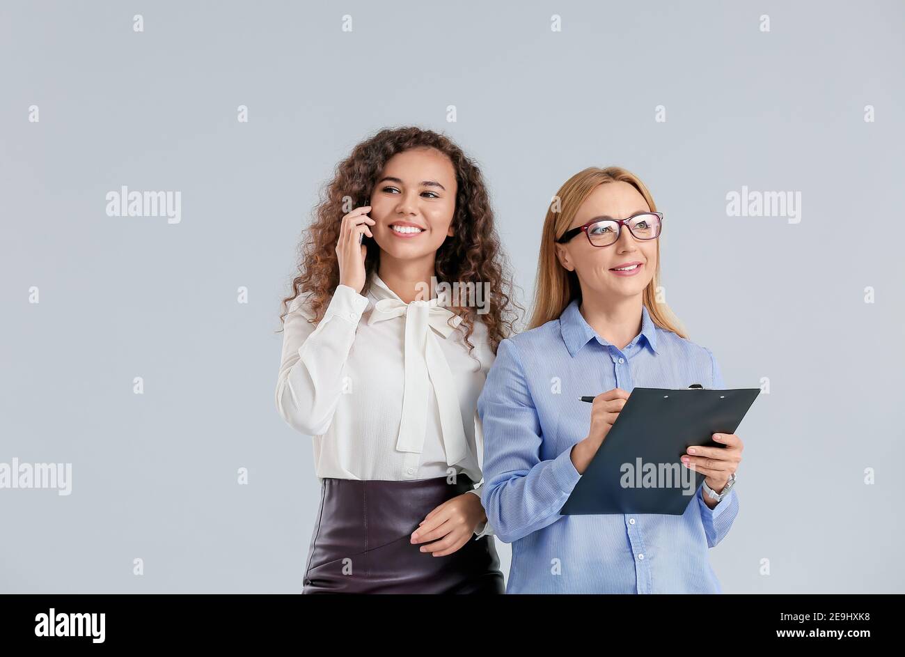 Beautiful businesswomen on grey background Stock Photo - Alamy