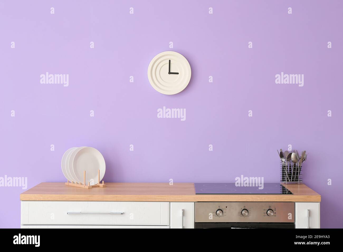 Kitchen counter with electric stove against color wall Stock Photo Alamy