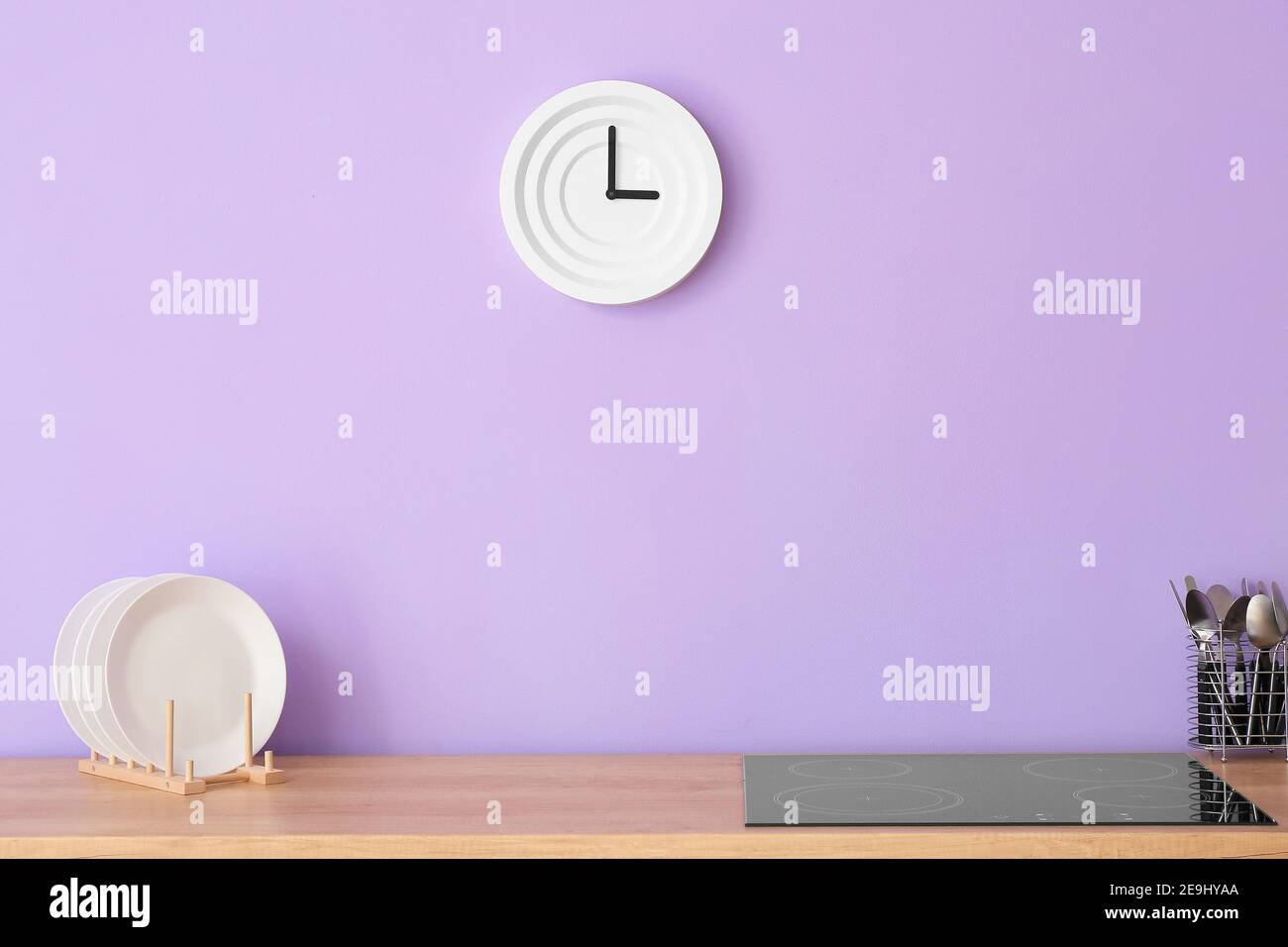 Kitchen counter with electric stove against color wall Stock Photo Alamy