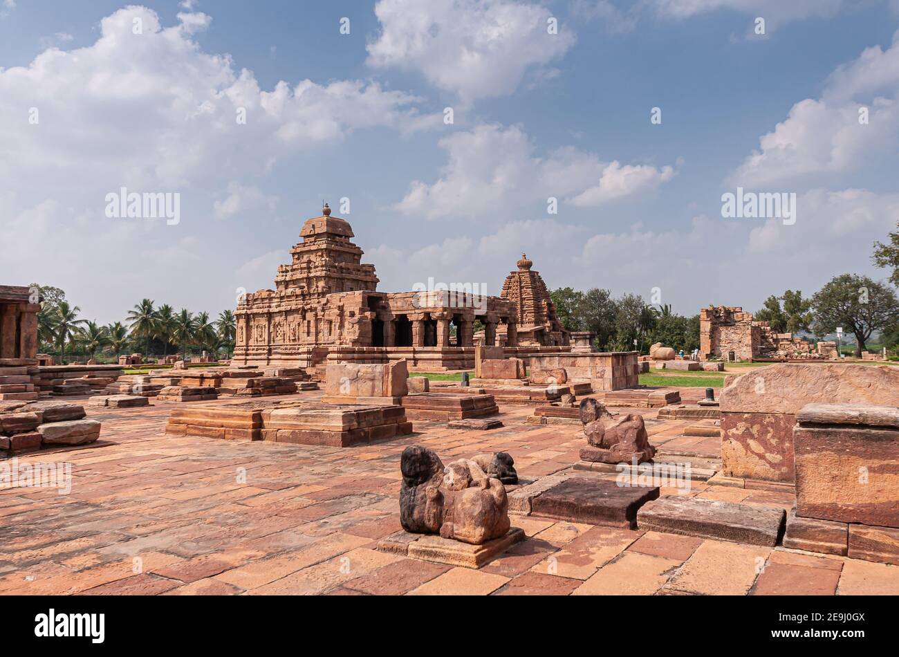 Bagalakote, Karnataka, India - November 7, 2013: Pattadakal temple complex. View over brown stone ruimous temple buildings under blue cloudscape. Dama Stock Photo