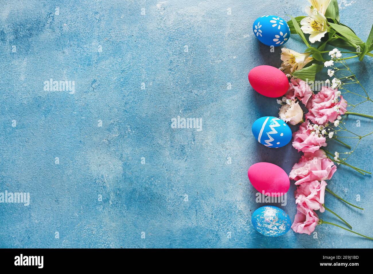 Composition with beautiful Easter eggs and flowers on color background ...