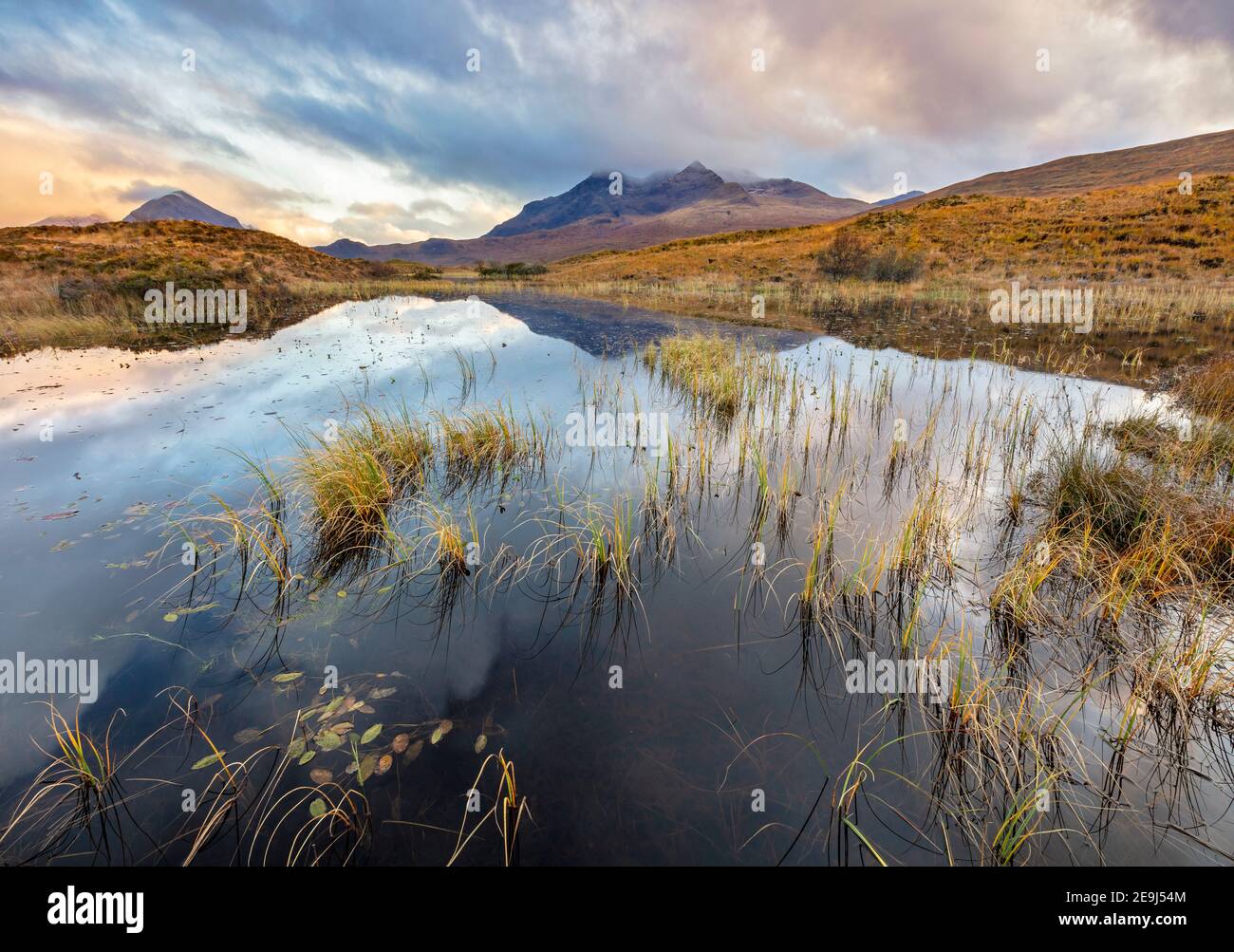 Isle of Skye, Scotland: Morning clouds clearing over the Cuillin mountains with reflections in a pond near Sligachan Stock Photo