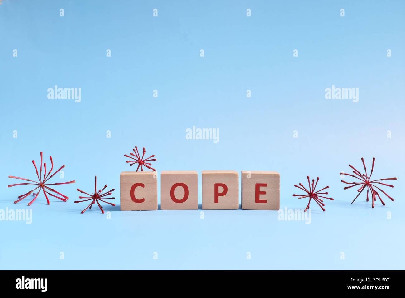 Cope word in wooden blocks on blue background. Coping with anxiety, stress, ptsd and depression during covid-19 pandemic concept. Stock Photo
