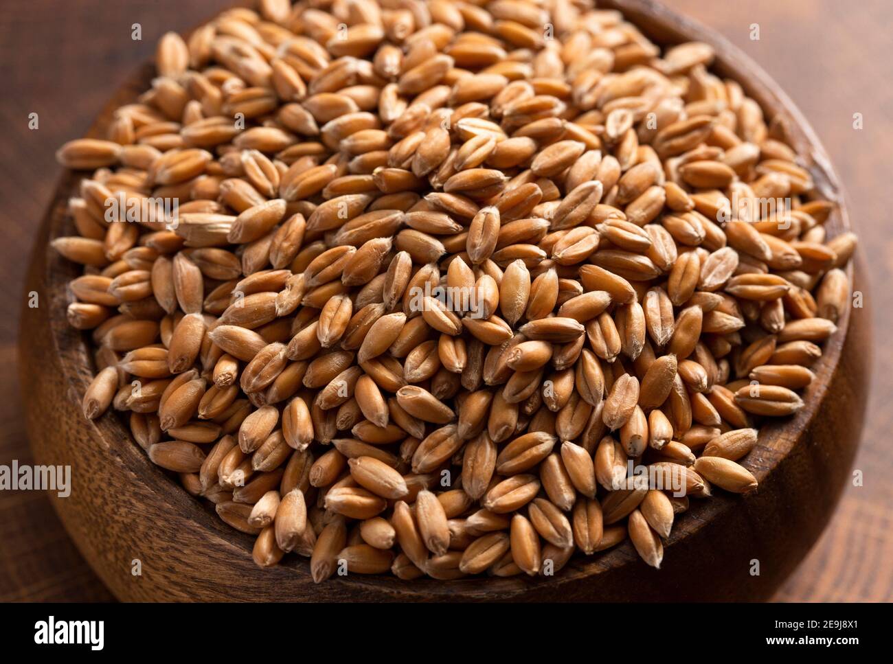 A Bowl of Spelt Grain on a Wooden Butchers Block Stock Photo