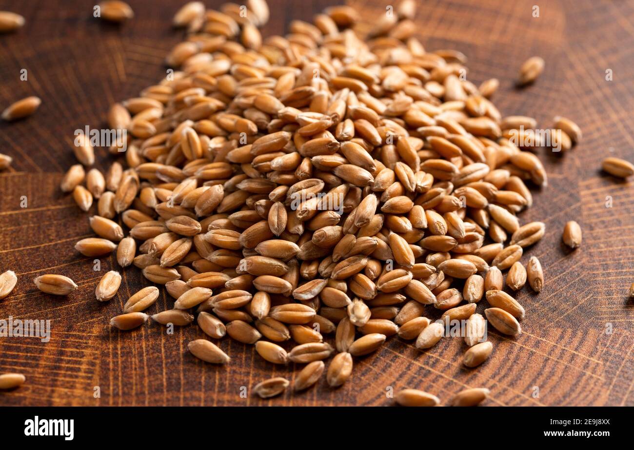 A Pile of Spelt Grain on a Wooden Butchers Block Stock Photo