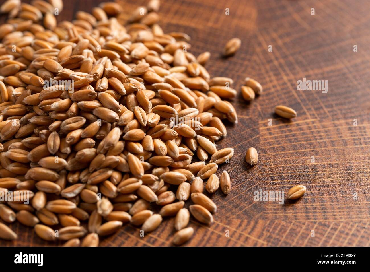 A Pile of Spelt Grain on a Wooden Butchers Block Stock Photo