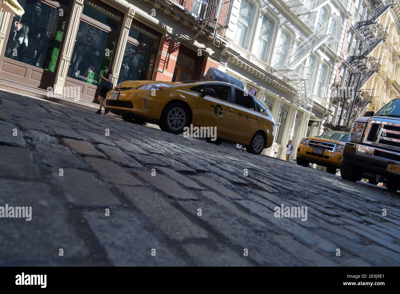 New York City, NY USA Low angle of a New York Taxi Cab on cobble stone road  in Soho Stock Photo