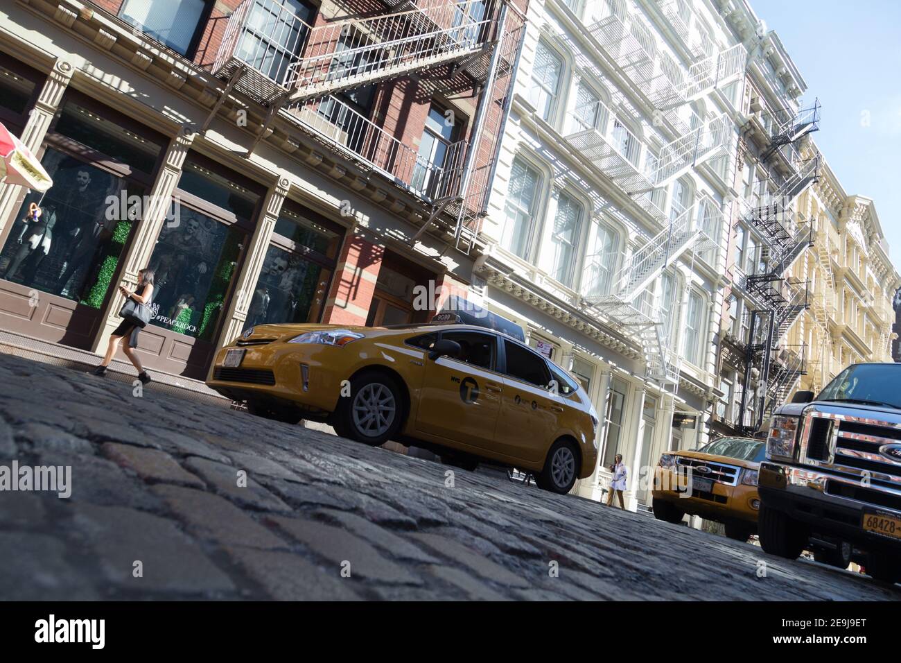 New York City, NY USA Low angle of a New York Taxi Cab on cobble stone road  in Soho Stock Photo