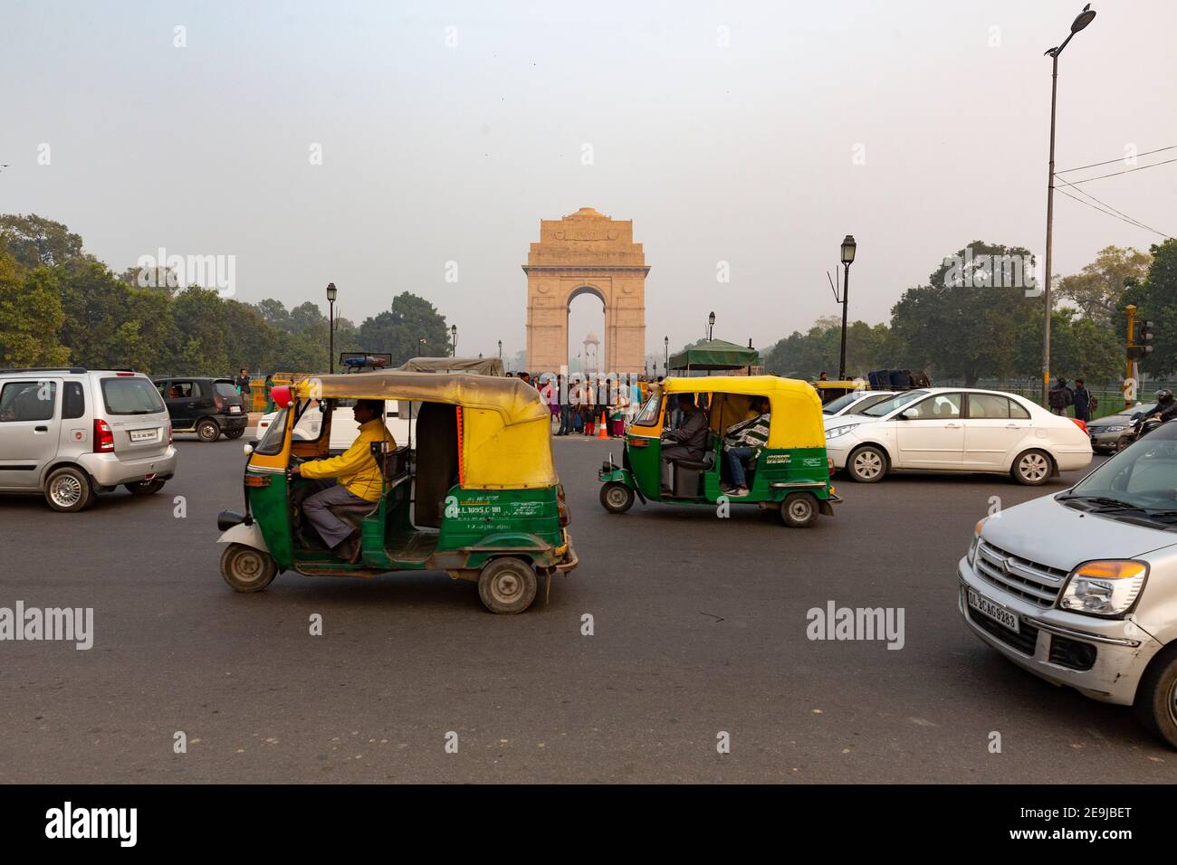 Traffic of Tuk tuks and cars pass India Gate.  India Gate,  designed by Sir Edwin Lutyens. commemorates the 70,000 Indian soldiers who lost their live Stock Photo