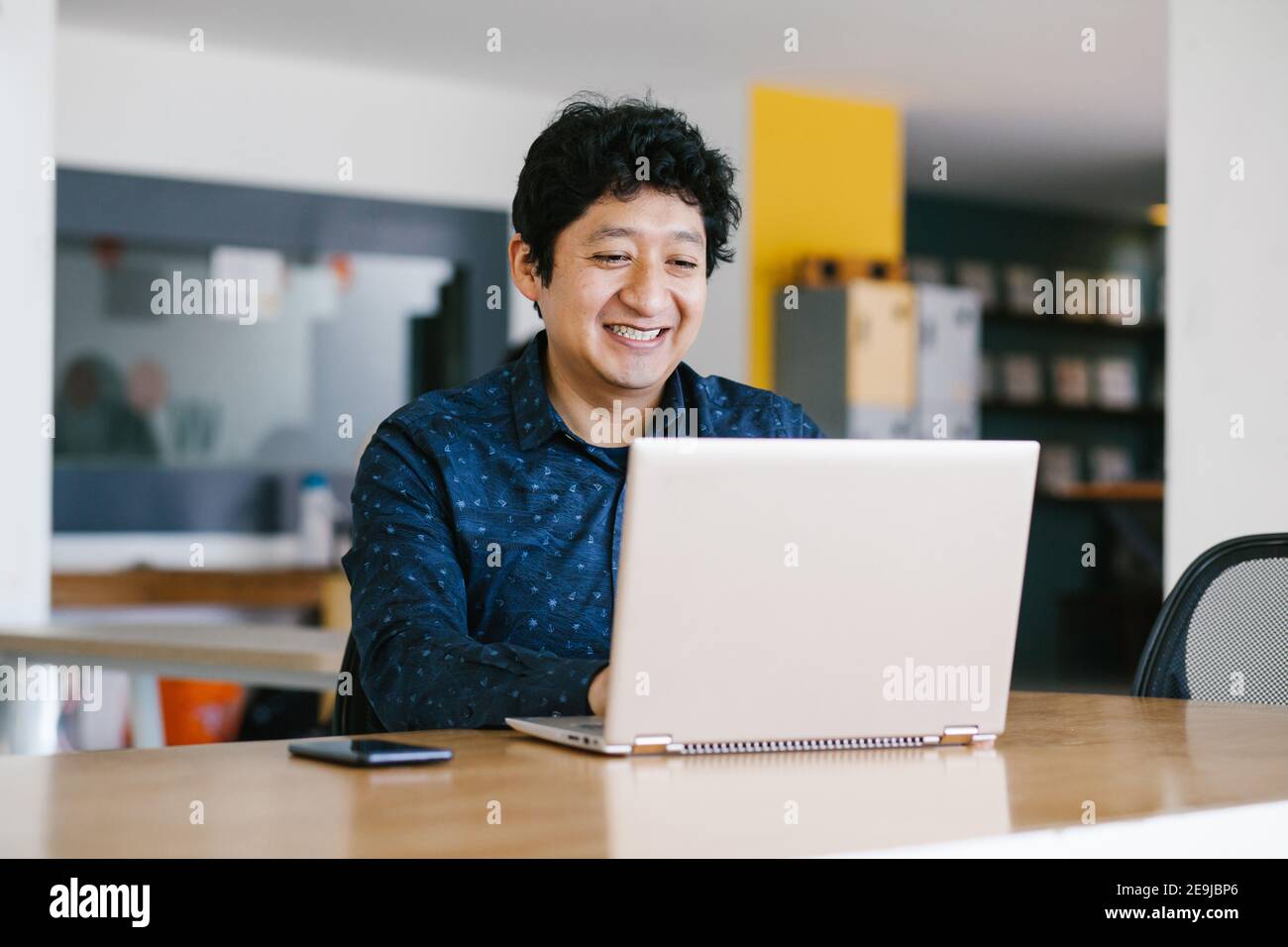 Young latin businessman working at his desk at office in Mexico city