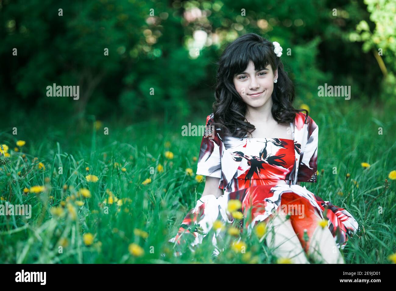 Young girl sitting in the green grass in the summer park Stock Photo ...