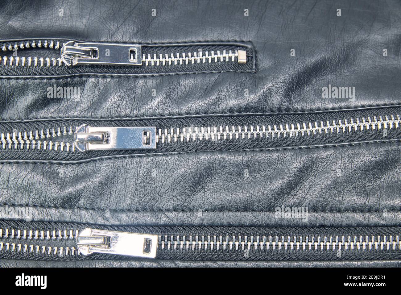 Detail of the metal zippers of the classic black leather jacket. Men