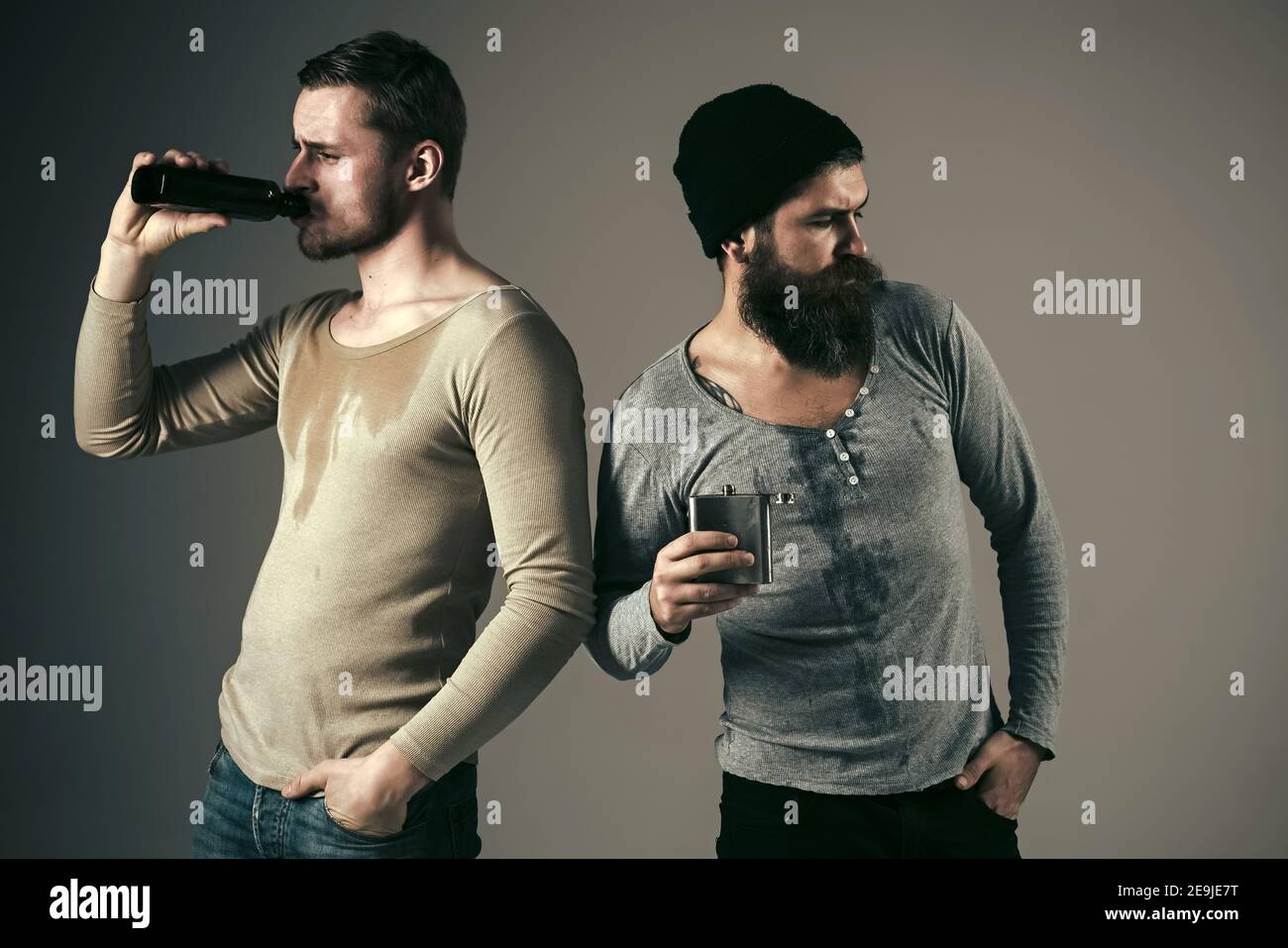 Alcohol addiction. Guys hold bottle and flask with alcohol, drinking ...