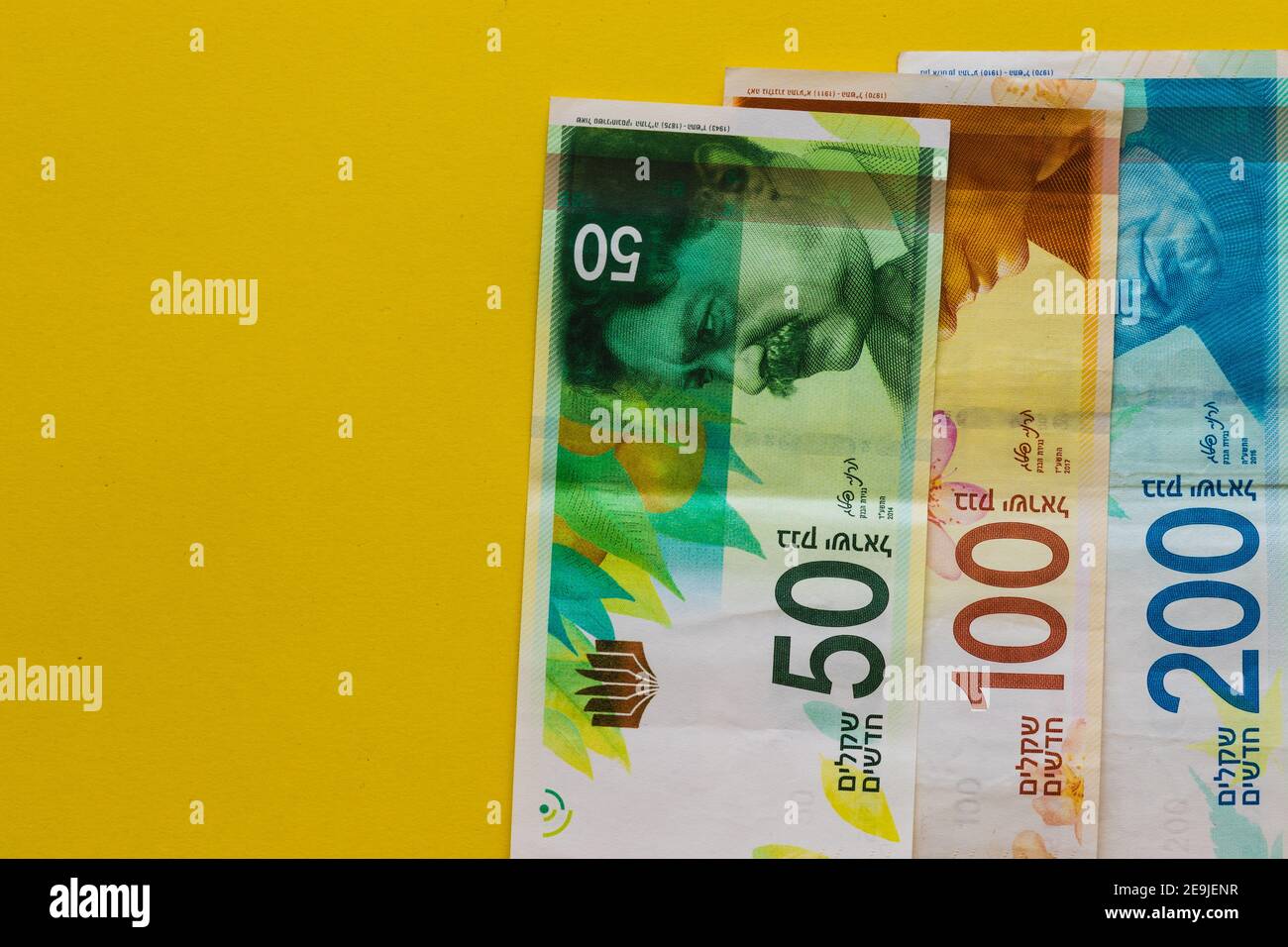 New Israeli banknotes of one hundred, two hundred and fifty shekels, yellow background Stock Photo