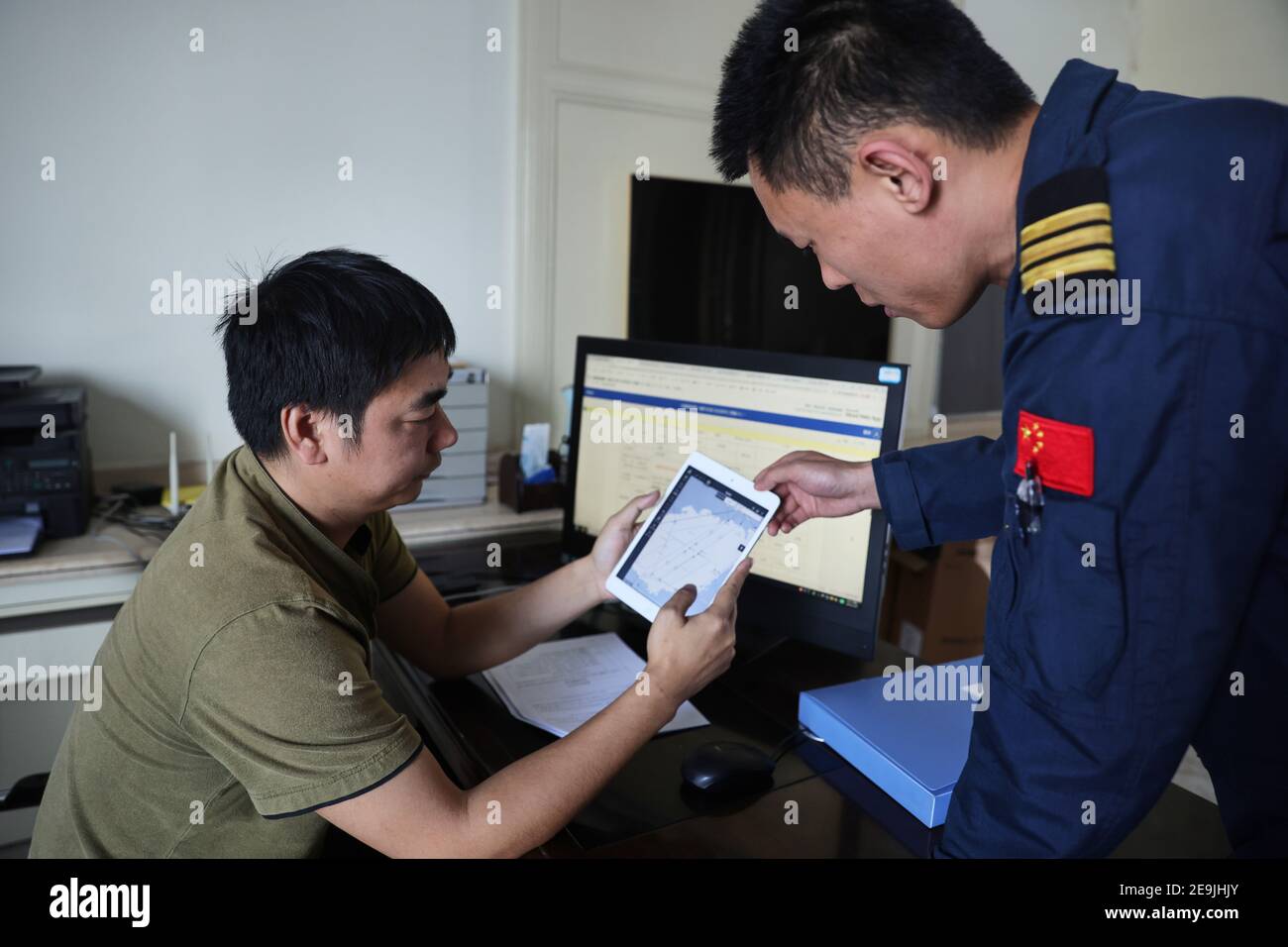 (210205) -- SANYA, Feb. 5, 2021 (Xinhua) -- Li Hangbing (L) and Sun Dongsheng, both members of the Nanhai No. 1 Flying Service of Ministry of Transport, an air rescue and aid team, make a flight plan in Sanya City of south China's Hainan Province, Jan. 29, 2021. Critical moments of life or death are of a common memory to all members of the air rescue and aid team. As the only state-run force of air rescue and aid over waters around south China, the team has brought 94 people back to safety in 2020 alone. Amid each onslaught of typhoon when all ships haste home, rescue helicopters of the team a Stock Photo