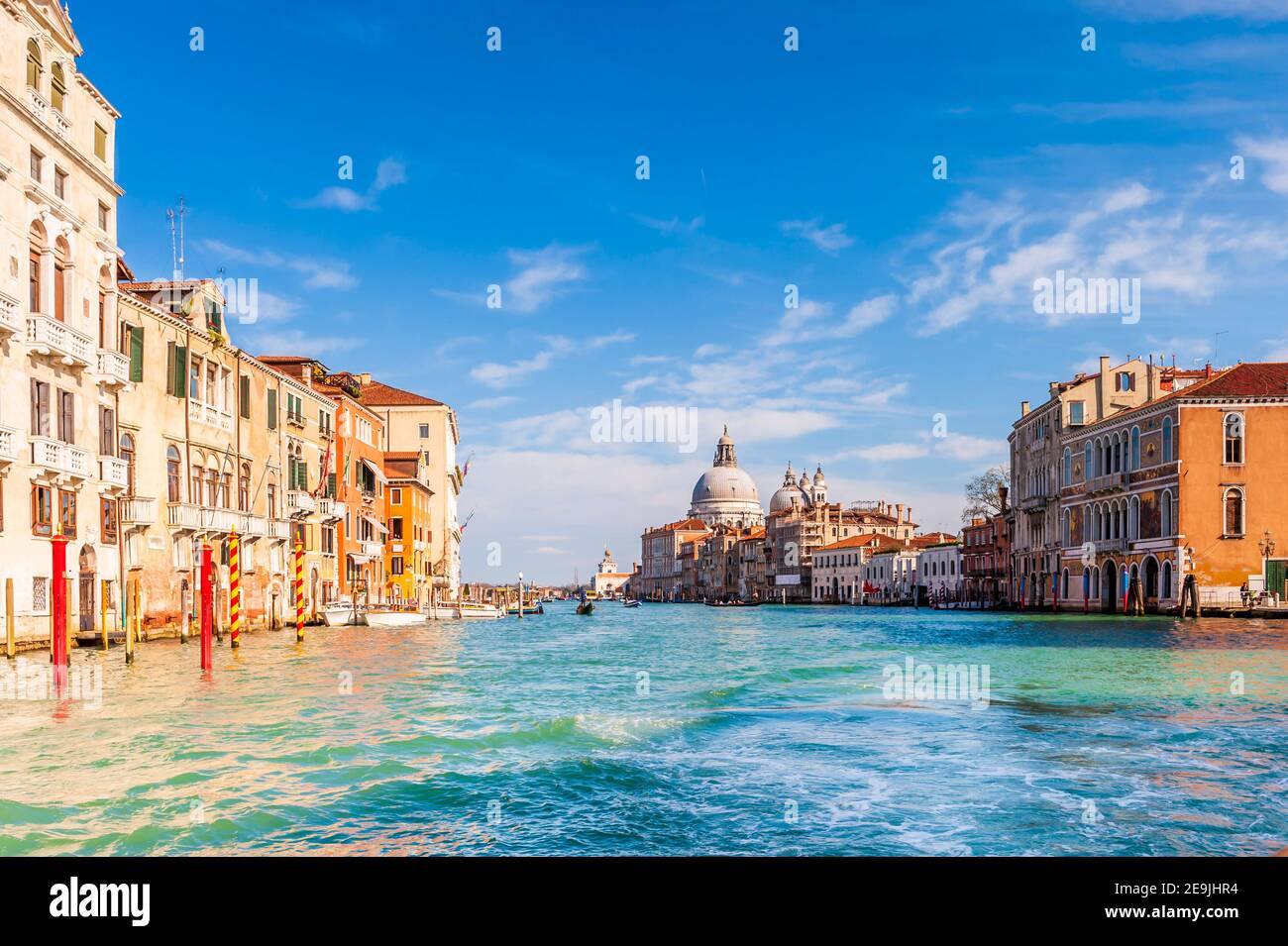 The Grand Canal and its facades and the Basilica of Santa Maria della salute in the background in Venice in Veneto, Italy Stock Photo