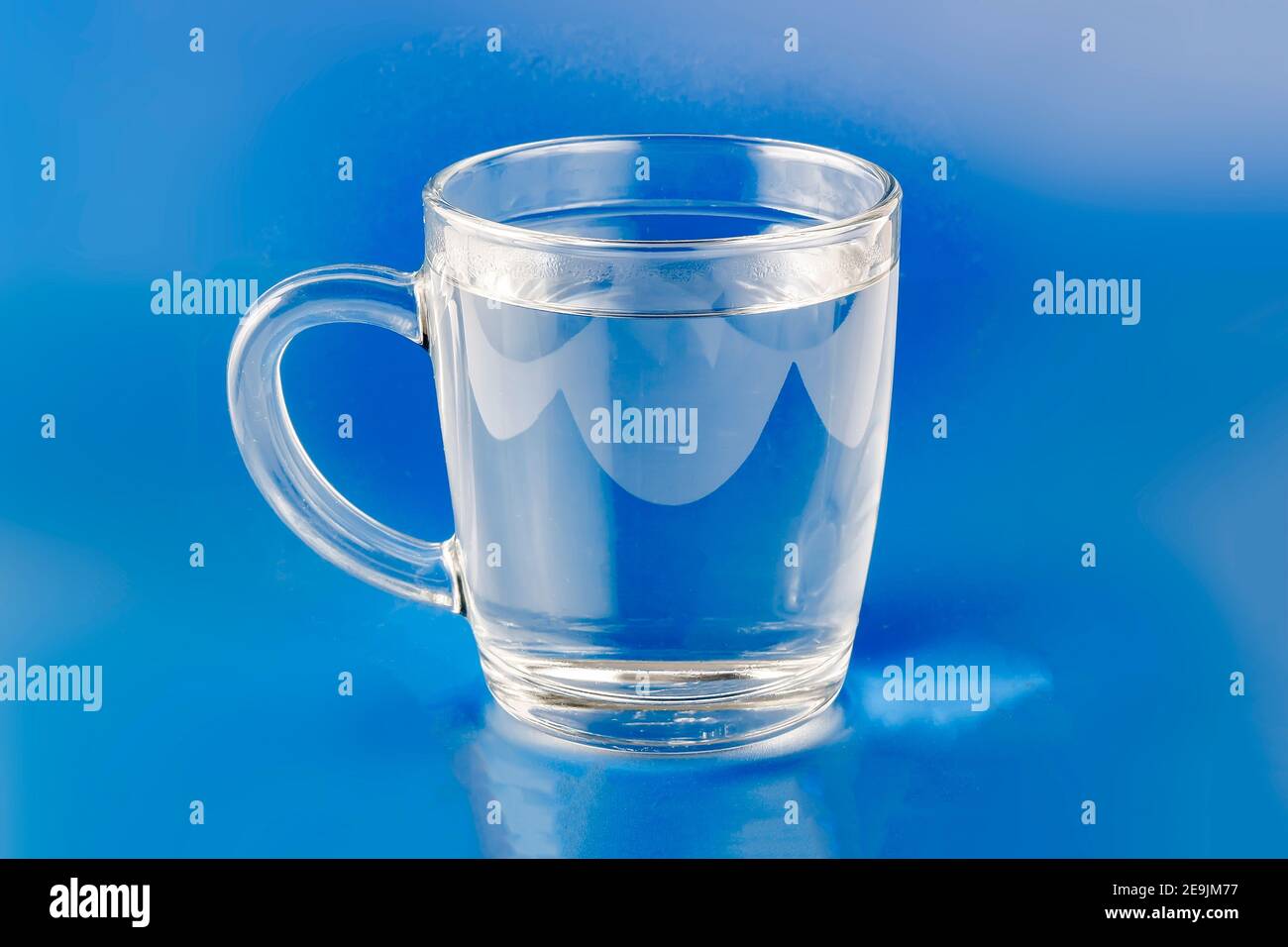 glass tumbler with clear water handle on blue background Stock Photo
