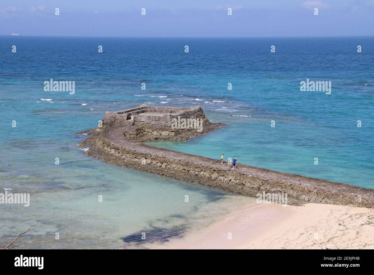 Historical relic site of old stone causeway to the 'gusuku' (stone walls) observation point, along the coastline below the gala complex and ocean's pi Stock Photo