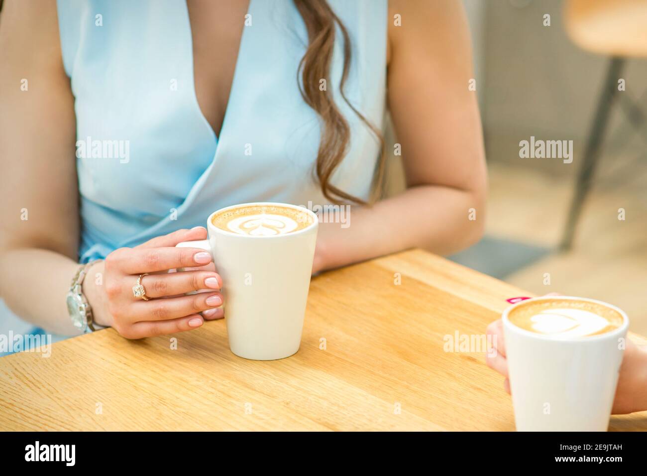 Female hands with cups of coffee on the background of a wooden table in ...