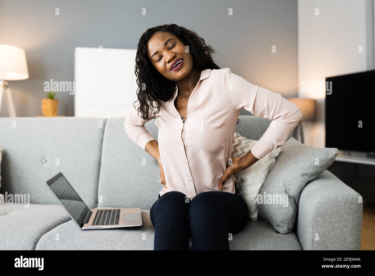 Lower Back Pain. Bad Posture Sitting On Couch Stock Photo Alamy
