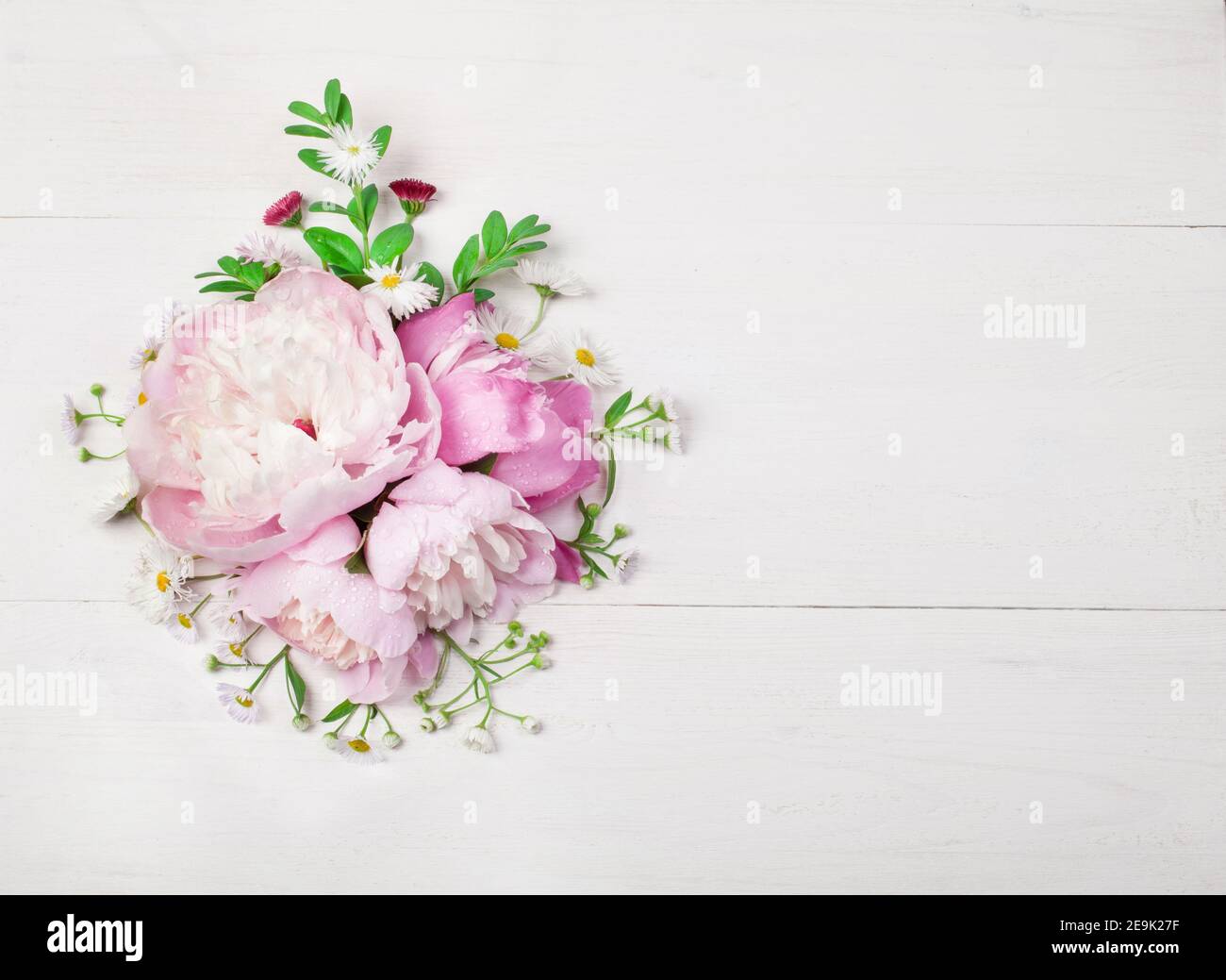 Bouquet of beautiful flowers on white wooden background. Top view. Copy space Stock Photo