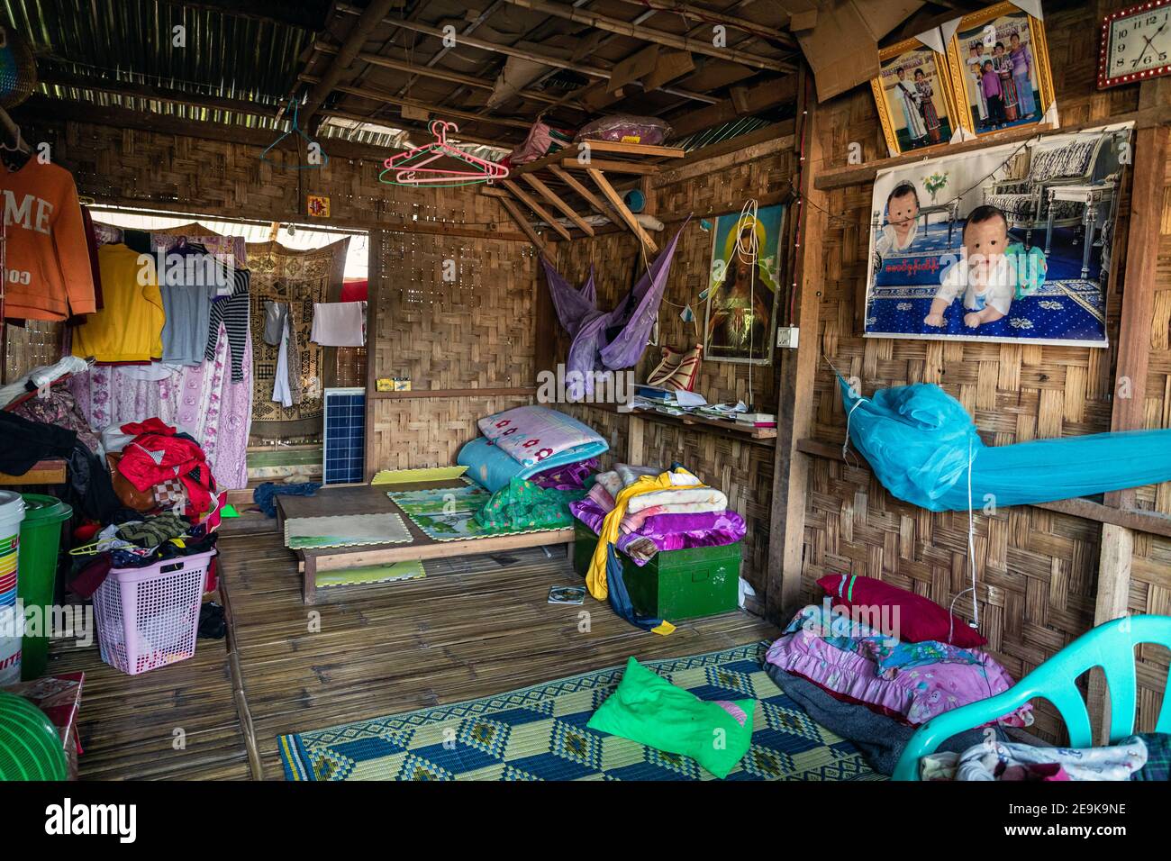 Daily life of the refugees in Shatapru IDP refugee camp in Myikyina, Myanmar. Each family has a room in the poor huts. Stock Photo