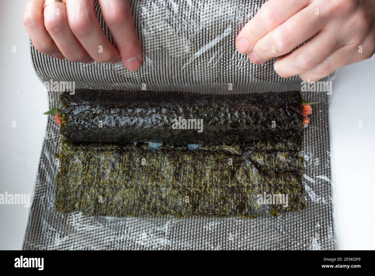 Woman using bamboo rolling mat for home made sushi Stock Photo - Alamy