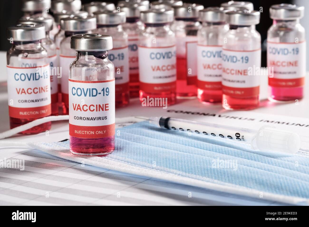 Vaccine vial, syringe and many glass bottles on background for vaccination  Stock Photo