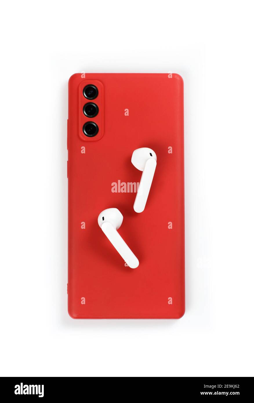 Smartphone with red cover and white wireless earphones top view on white background Stock Photo