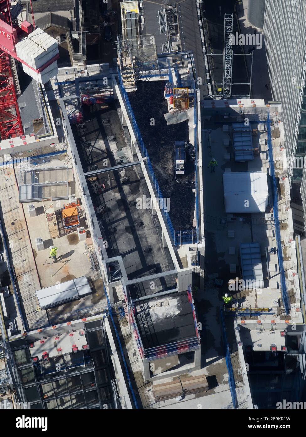 aerial view of construction workers on top of a tall building seen from above Stock Photo