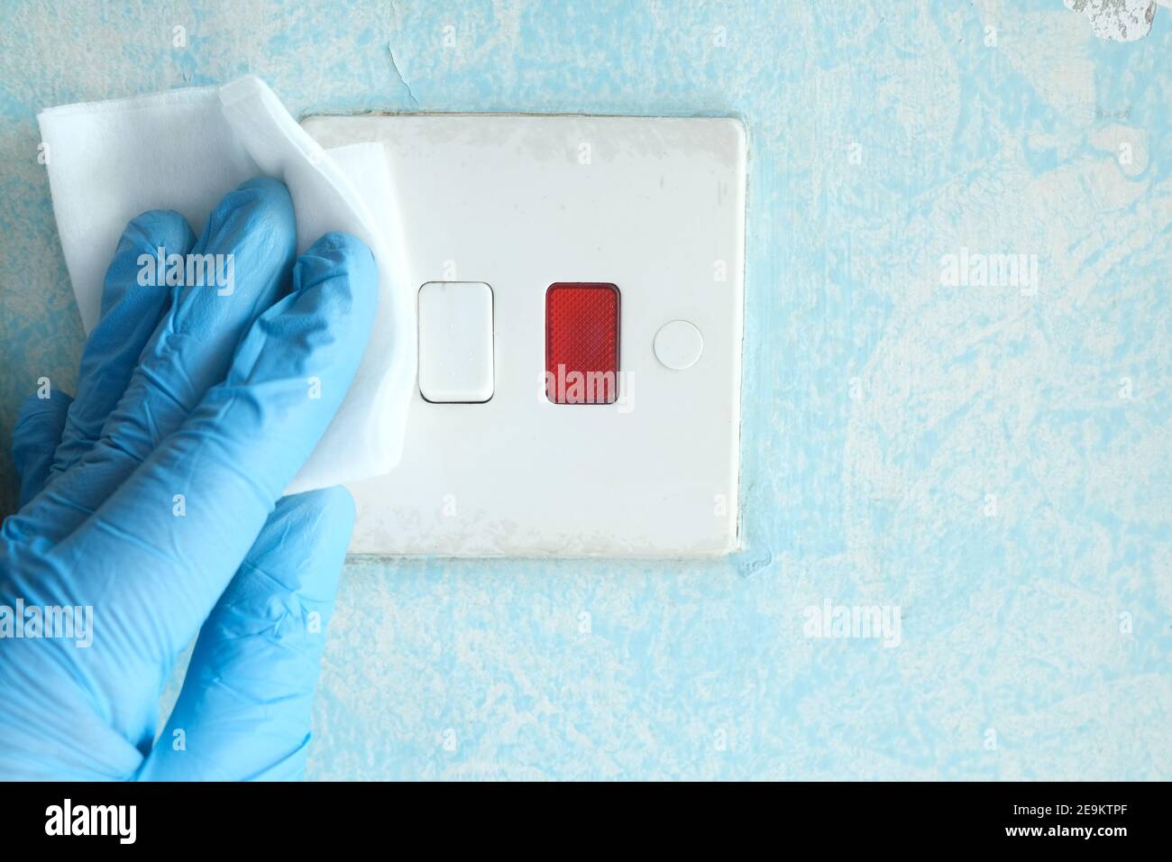 cleaning and disinfecting electrical switch wiping with tissue Stock